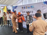 Penjabat Sekretaris Daerah Kota Balikpapan, Agus Budi saat memasangkan jaket dan pemberian mesin IDC kepada perwakilan Jukir di kawasan Balikpapan Permai, Selasa (6/1/2026)