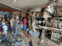 Kondisi dump truck bermuatan batu koral yang terbalik dan menabrak bengkel di Jalan Mulawarman, Bengalon, Kutim, setelah mengalami rem blong.(Dok: tio/expresi)