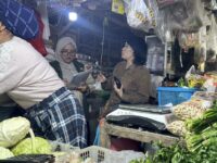 Petugas Disperindag Kutai Timur melakukan pemantauan dan pencatatan harga bahan pokok di salah satu lapak pedagang pasar.(Dok: tio/expresi)